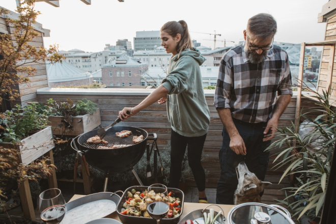 een koppel staat samen te barbecueën op balkon